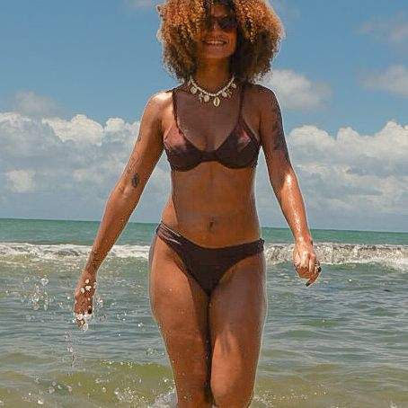 Mulher de biquíni marrom saindo do mar